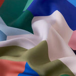Motif coloré abstrait sur tissu drapé, mêlant harmonieusement des teintes de bleu, vert, blanc et rose pour un effet visuel captivant. Ideal pour la décoration intérieure moderne ou la création de vêtements originaux, ce design élégant apporte une touche artistique et dynamique.