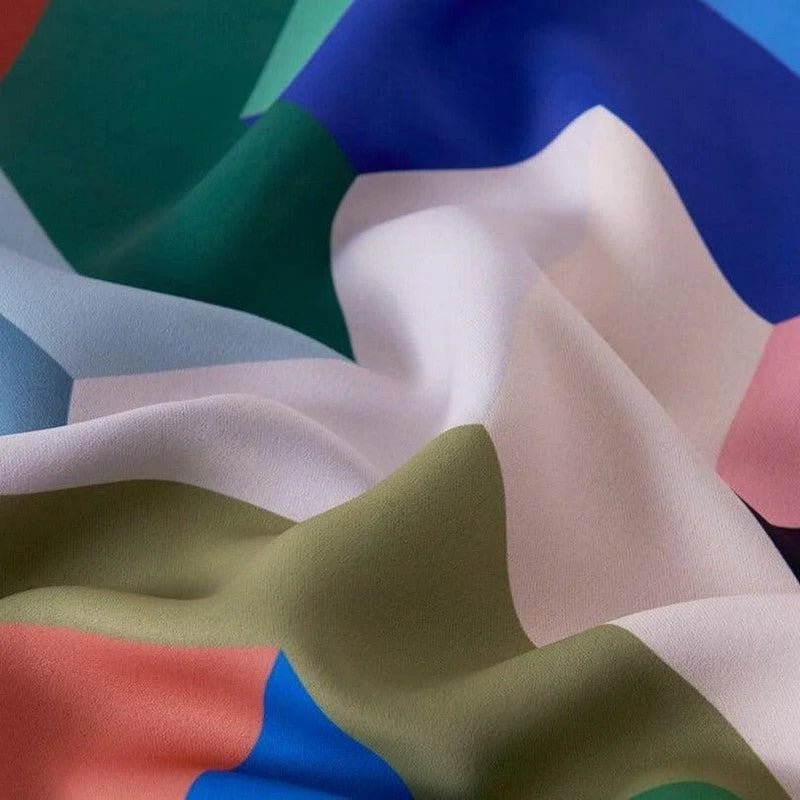 Motif coloré abstrait sur tissu drapé, mêlant harmonieusement des teintes de bleu, vert, blanc et rose pour un effet visuel captivant. Ideal pour la décoration intérieure moderne ou la création de vêtements originaux, ce design élégant apporte une touche artistique et dynamique.