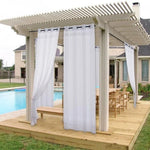 Pergola élégante avec rideaux blancs installée sur une terrasse en bois près d'une piscine. Espace extérieur parfait pour des repas en plein air et pour se détendre à l'ombre. Conception moderne idéale pour les jardins et les espaces extérieurs. Optimisé pour le confort et l'intimité.