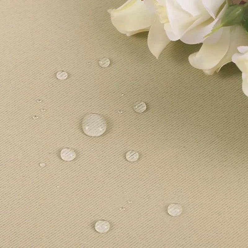 Gouttelettes d'eau sur une surface beige montrant l'effet résistant aux liquides, avec des fleurs blanches en arrière-plan, indiquant une protection efficace contre l'humidité. Solution idéale pour une utilisation en extérieur ou dans des environnements exigeant une résistance à l'eau.