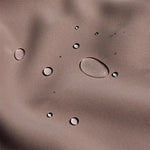 Gouttes d'eau sur surface imperméable, démontrant l'efficacité de la protection contre l'humidité. Idéal pour activités extérieures et conditions météorologiques variées. Fabrication soignée garantissant durabilité et performance optimale.