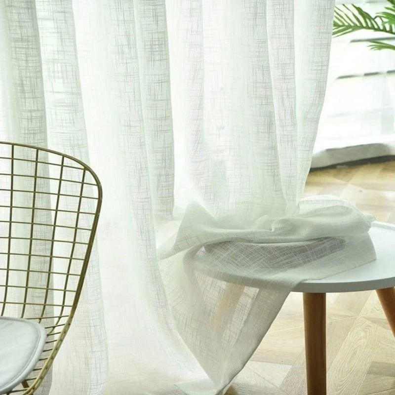 Voilage blanc élégant tombant gracieusement, idéal pour apporter une touche contemporaine à votre intérieur. Conçu pour filtrer délicatement la lumière tout en préservant votre intimité, ce rideau s'adapte parfaitement aux décors modernes et minimalistes. Parfait pour un salon lumineux ou une chambre apaisante.