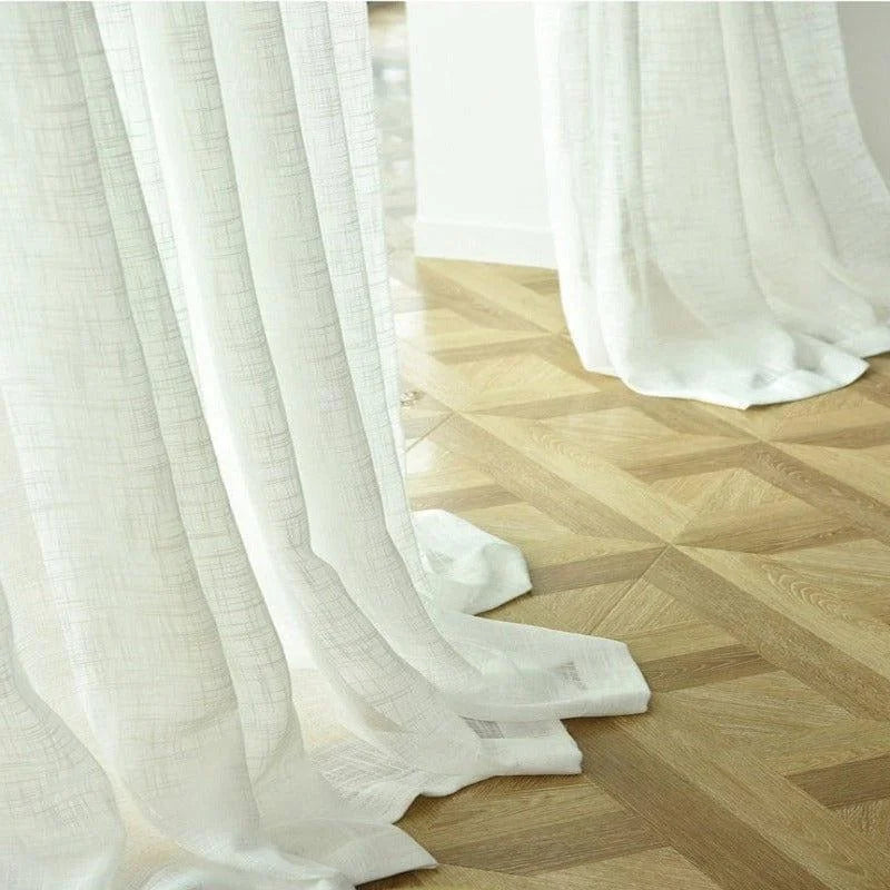 Rideaux blancs élégants et transparents, parfaits pour filtrer délicatement la lumière naturelle, ajoutant une touche de sophistication à n'importe quelle pièce. Ces rideaux complètent magnifiquement un parquet en chevrons, créant une atmosphère lumineuse et apaisante idéale pour le salon ou la chambre.