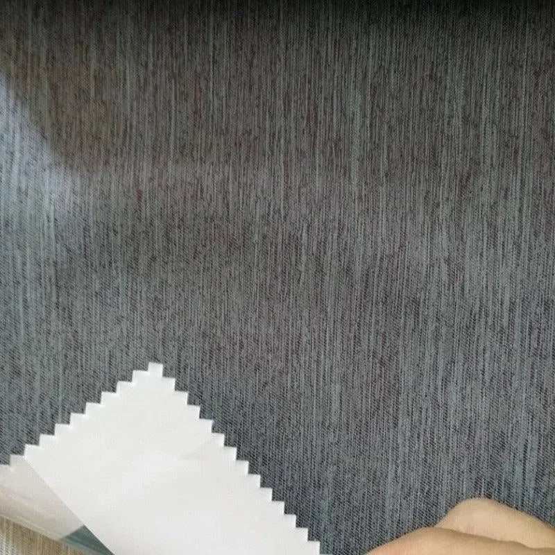 Tissu gris pour ameublement, échantillon sur fond ligneux. Parfait pour rideaux modernes ou revêtements de canapé, apporte une touche élégante à tout intérieur.