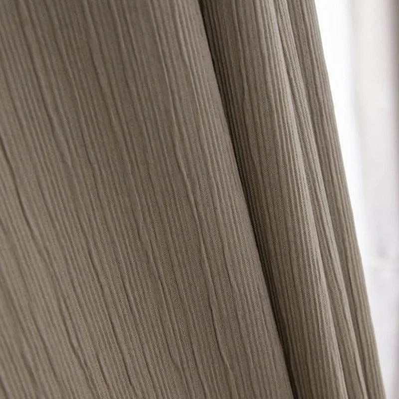 Rideau moderne beige avec texture plissée verticalement offrant une ambiance chaleureuse et élégante à votre intérieur, idéal pour salon ou chambre à coucher.