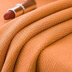 Serviette de bain orange douce et absorbante, idéale pour les moments de détente après une douche. Le rouge à lèvres assorti ajoute une touche d'élégance et de couleur à votre routine beauté. Accessoire parfait pour une salle de bain moderne et stylée.