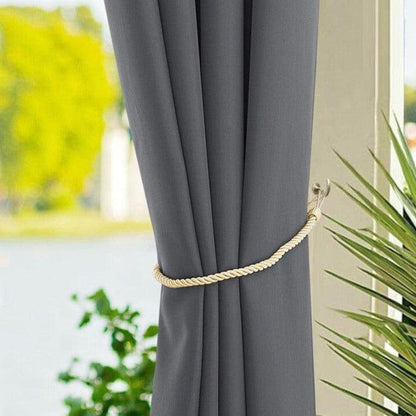 Rideau d'intérieur élégant gris pour salon moderne, attaché avec une corde décorative beige, offrant une ambiance chaleureuse et raffinée à votre décoration. Vue sur un jardin luxuriant par la fenêtre, parfait pour filtrer la lumière tout en embellissant votre espace de vie. Accessoire idéal pour personnaliser votre intérieur.