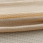 Tissu beige à motif géométrique chevron offrant un design élégant pour la décoration intérieure ou la confection de vêtements, idéal pour un style moderne et raffiné.