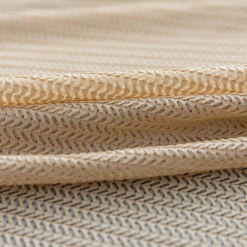 Tissu beige à motif géométrique chevron offrant un design élégant pour la décoration intérieure ou la confection de vêtements, idéal pour un style moderne et raffiné.