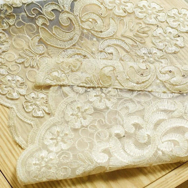 Dentelle dorée raffinée avec motifs floraux détaillés, idéale pour des créations de mode élégantes ou des projets de décoration. Parfait pour apporter une touche de sophistication et de luxe.