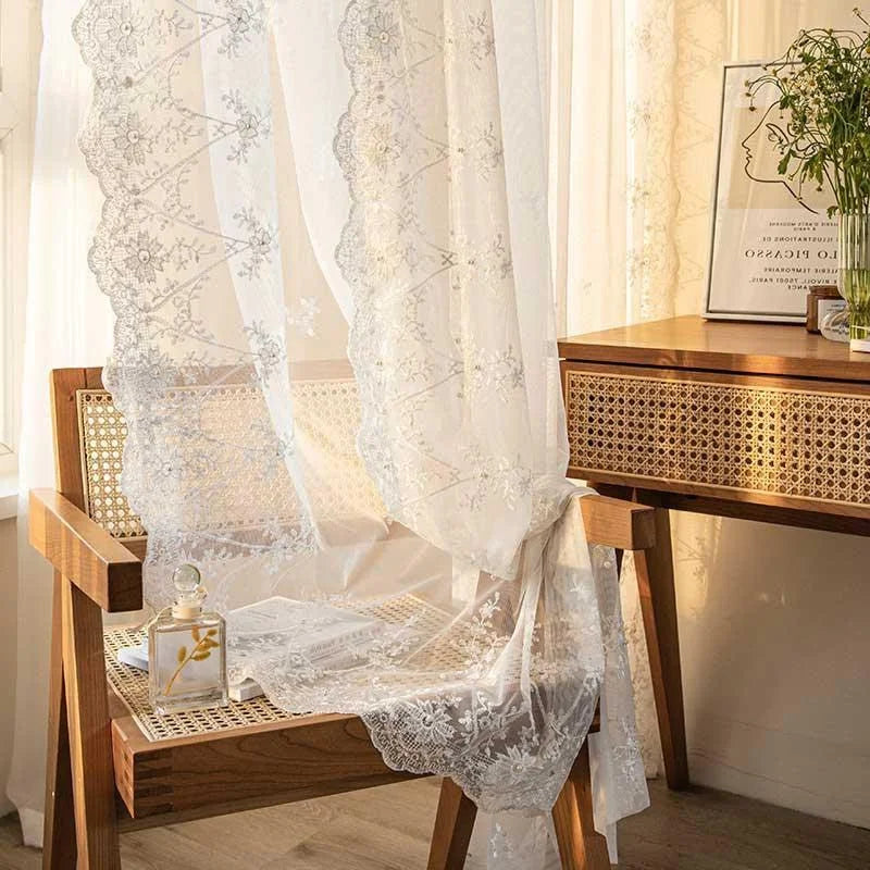 Voilage décoratif élégant avec motifs floraux, accentuant la lumière naturelle dans un intérieur chaleureux. Idéal pour une décoration de salon ou chambre à coucher, ce rideau apporte une touche de sophistication et de charme à votre espace de vie. Associez-le à des meubles en bois pour un style authentique et raffiné.