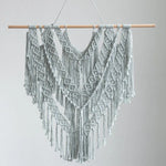 Décoration murale en macramé bohème chic avec motifs géométriques, idéale pour ajouter une touche d'élégance ethnique à votre intérieur. Cette pièce artisanale authentique capte l'attention par ses détails raffinés et ses franges harmonieuses. Parfait pour le salon ou une chambre, offrant une ambiance cosy et tendance.