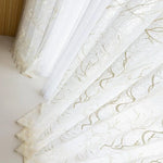 Rideaux élégants blancs avec motifs dorés discrets, parfaits pour ajouter une touche sophistiquée à votre salon ou chambre à coucher, tout en laissant passer une lumière naturelle apaisante. Accessoire idéal pour rehausser la décoration intérieure de votre maison.