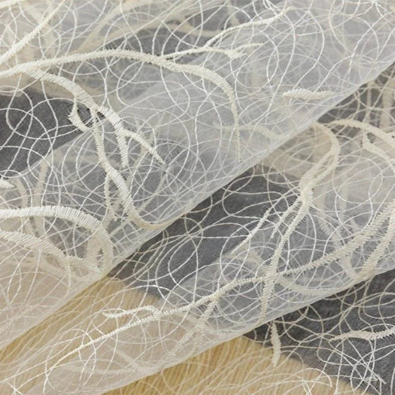 Voile délicat brodé avec des motifs blancs élégants. Parfait pour la décoration intérieure, la confection de tenues ou la création d'accessoires personnalisés. Idéal pour apporter une touche de sophistication à tout projet créatif.