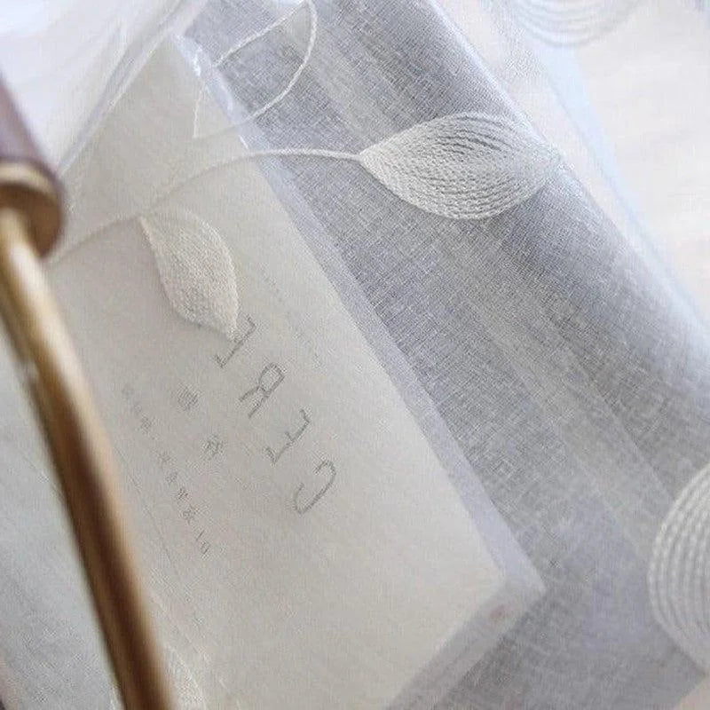 Voilage transparent décoratif avec motif feuille, idéal pour habiller les fenêtres tout en laissant passer la lumière. Créez une atmosphère douce et élégante dans votre intérieur grâce à ce rideau délicat. Accessoire parfait pour ajouter une touche naturelle et raffinée à votre décoration.