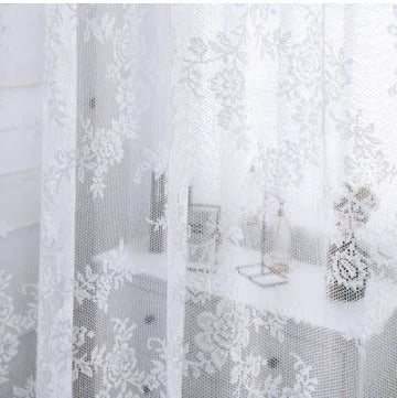 Voilage blanc transparent à motifs floraux habillant une fenêtre devant une coiffeuse, pour une ambiance douce et lumineuse dans la chambre ou le salon.