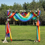 Arche de cérémonie colorée en plein air, idéale pour les mariages ou événements festifs. Ornée de tissus aux couleurs de l'arc-en-ciel et de feuillages, elle crée un cadre enchanteur pour vos réceptions en extérieur. Parfaite pour ajouter une touche de gaieté et d'élégance à votre décor.