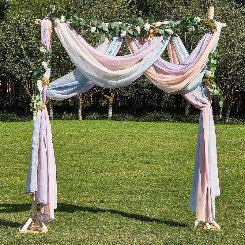 Arche de mariage élégante avec drapés pastel, ornée de feuillage vert et fleurs blanches. Parfaite pour une cérémonie en plein air, elle ajoute une touche romantique à votre événement. Idéale pour les mariages champêtres, offrant une ambiance magique et sophistiquée dans un cadre naturel.