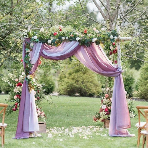 Arche de mariage romantique en plein air, décorée avec élégance de drapés violets et de fleurs fraîches. Idéale pour créer une ambiance magique et naturelle lors d'une cérémonie de mariage en extérieur.
