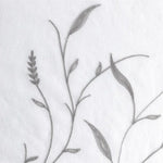Broderie florale grise sur fond blanc, design élégant et raffiné idéal pour ajouter une touche naturelle à votre décoration intérieure. Motifs de feuilles et d'épis finement réalisés pour un effet délicat et moderne. Parfait pour une chambre à coucher ou un salon chic.