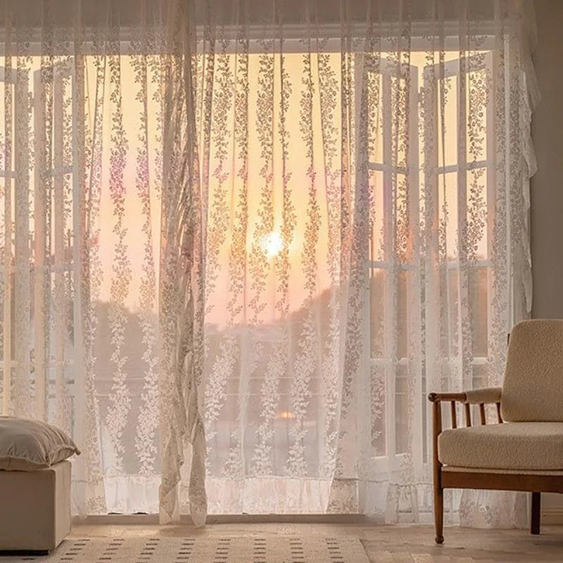 Voilage élégant pour salon, offrant une touche décorative raffinée avec motifs floraux délicats. Laisse passer la lumière naturelle pour un intérieur lumineux et chaleureux. Idéal pour créer une ambiance cosy avec vue sur le coucher de soleil. Spécialement conçu pour embellir vos espaces de vie avec style et élégance.