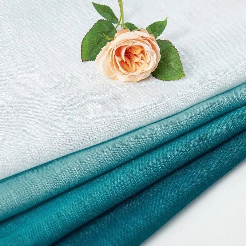 Tissus colorés dans des tons de bleu et blanc avec une rose en décoration, parfaits pour la décoration intérieure et la confection de rideaux élégants.