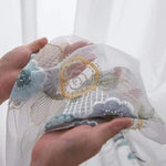 Voile décoratif brodé avec motifs floraux délicats, idéal pour embellir les fenêtres ou créer des rideaux élégants. Ce textile raffiné, orné de détails perlés, ajoute une touche d'élégance et de charme à votre intérieur, parfait pour les salons ou les chambres à coucher. Transformez votre espace avec ce voilage chic et artistique.