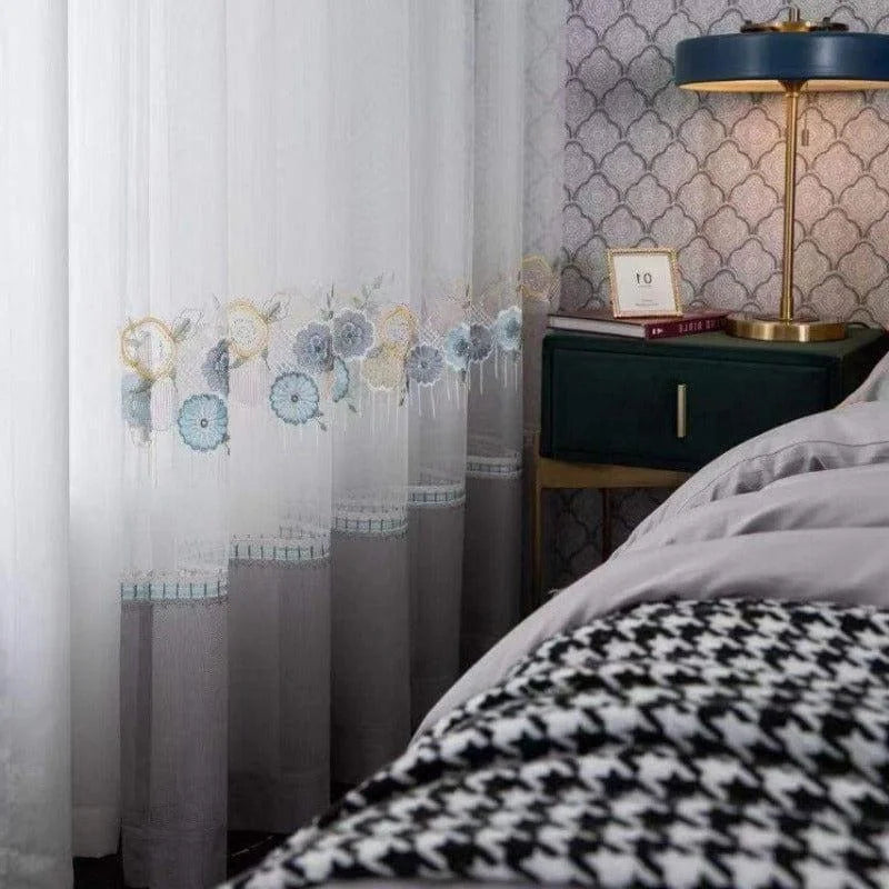 Rideaux élégants avec motifs floraux bleus et jaunes, idéal pour une chambre chic. Décoration intérieure moderne avec table de chevet verte, lampe élégante et papier peint texturé. Parfait pour apporter une touche de charme et de sophistication à votre espace de vie.