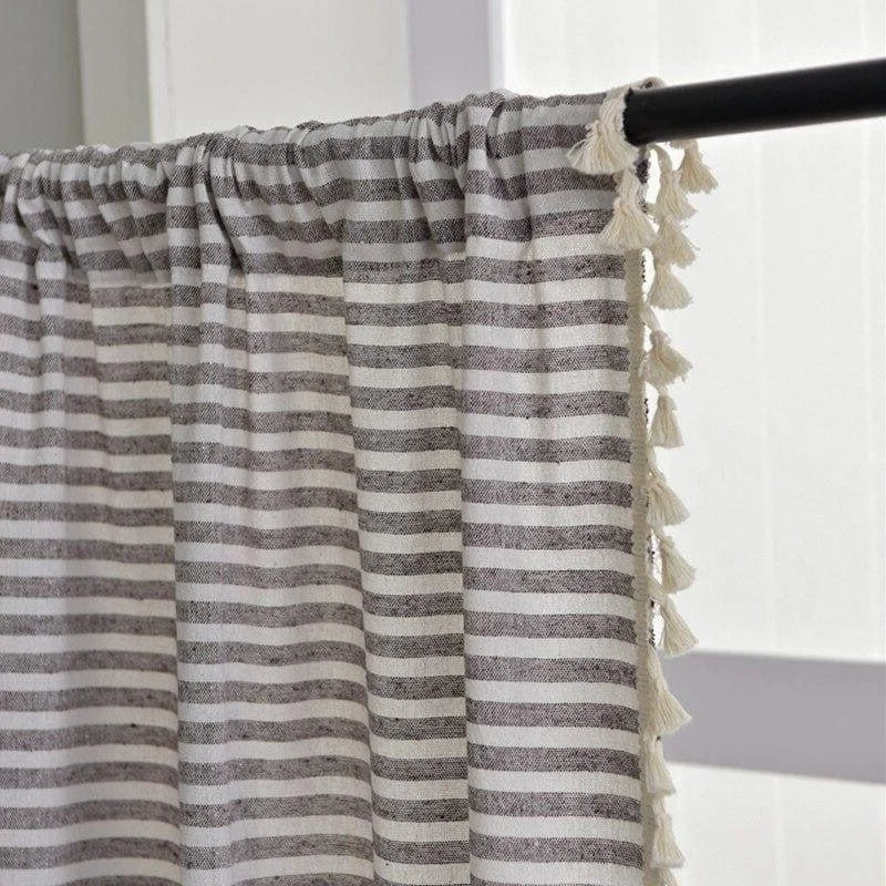 Rideau à rayures grises et blanches avec des franges décoratives, idéal pour ajouter une touche élégante et moderne à votre intérieur. Parfait pour les salons, chambres ou espaces de vie, ce rideau se distingue par son style contemporain et sa capacité à diffuser la lumière tout en préservant l'intimité.