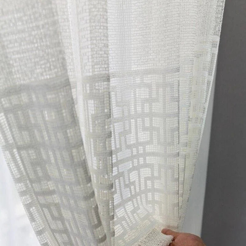 Voilage transparent élégant avec motifs géométriques, idéal pour embellir votre intérieur. Ce rideau moderne et stylé diffuse une lumière douce et crée une atmosphère chaleureuse dans votre salon ou chambre. Solution parfaite pour préserver l'intimité tout en ajoutant une touche de sophistication à votre décoration.