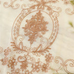 Dessin brodé orné de motifs floraux détaillés sur fond clair, idéal pour décoration intérieure élégante et raffinée, convenant parfaitement aux rideaux, nappes ou tentures.
