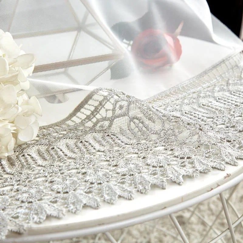 Nappe élégante avec bordure en dentelle sur une table décorée de fleurs blanches, idéale pour ajouter une touche de sophistication à votre salle à manger. Parfait pour les événements spéciaux et les décorations de table raffinées.