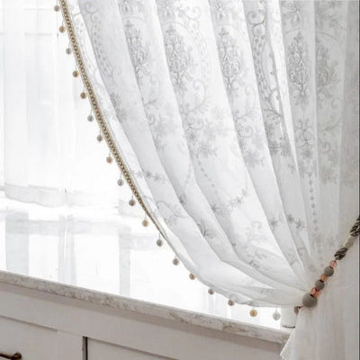 Rideaux décoratifs blancs avec motifs élégants et pompons, parfaits pour ajouter une touche sophistiquée à votre intérieur. Accessoire idéal pour salon ou chambre, permettant de créer une ambiance lumineuse et accueillante. Convient aux espaces modernes et classiques.