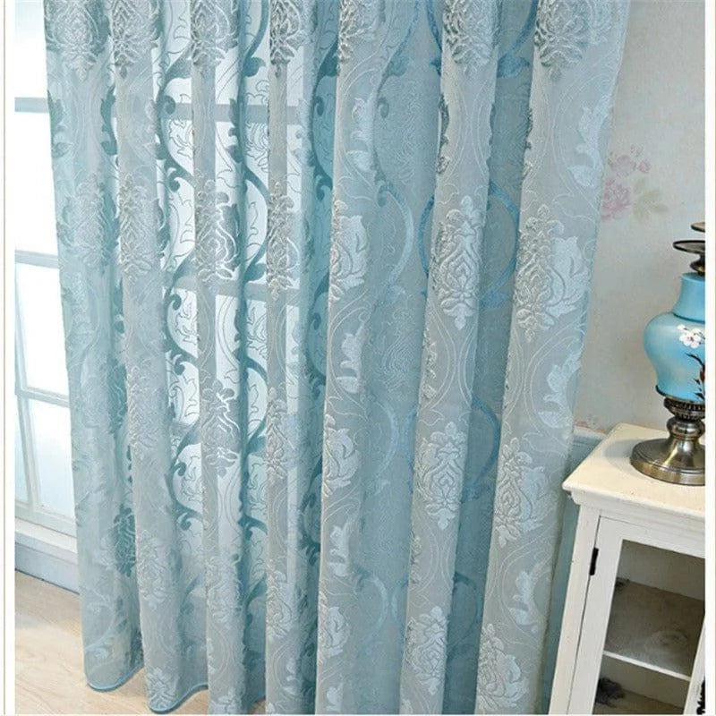Rideau bleu élégant avec motifs décoratifs floraux, idéal pour embellir un salon ou une chambre. Ce rideau ajoute une touche de sophistication et une ambiance apaisante à votre intérieur. Sa transparence subtile permet de filtrer doucement la lumière naturelle tout en préservant l'intimité. Parfait pour une décoration intérieure moderne et chic.