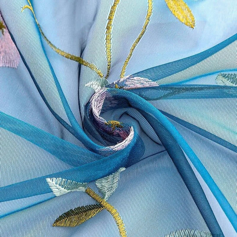 Voilage bleu élégant avec motif floral brodé, idéal pour ajouter une touche raffinée et colorée à votre décoration intérieure. Design délicat et esthétisme moderne parfaits pour les salons et chambres à coucher.
