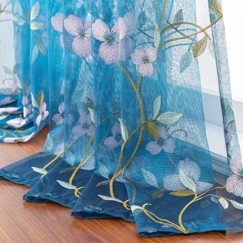 Rideau bleu avec motifs floraux brodés, idéal pour ajouter une touche élégante et naturelle à votre intérieur. Ce voilage délicat offre une excellente filtration de la lumière tout en préservant l'intimité de votre maison. Parfait pour le salon, la chambre ou toute autre pièce nécessitant une ambiance apaisante et raffinée.