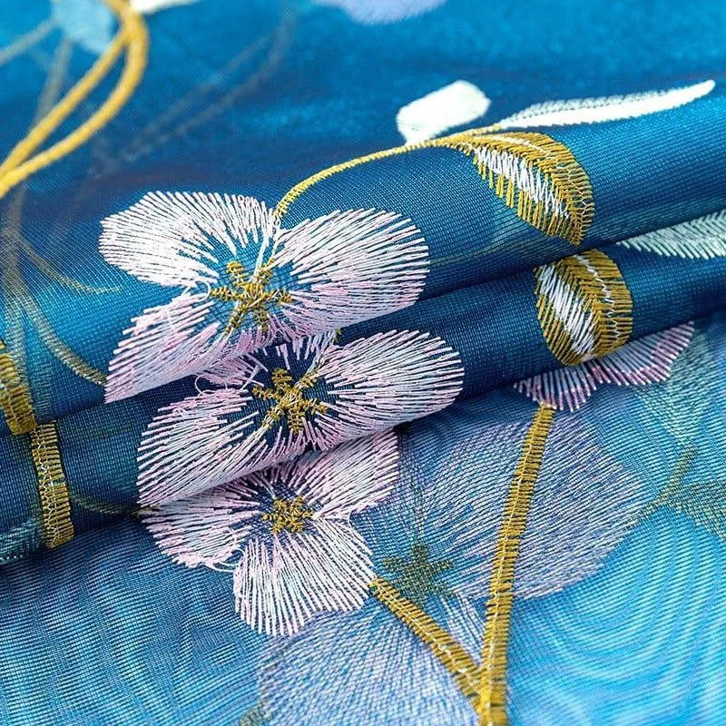 Élégant tissu brodé bleu avec motifs floraux raffinés, idéal pour la confection de vêtements ou projets créatifs. Ce design floral délicat et ses couleurs vives apportent une touche sophistiquée et stylée à toute réalisation. Parfait pour ajouter une note de charme et de fraîcheur.