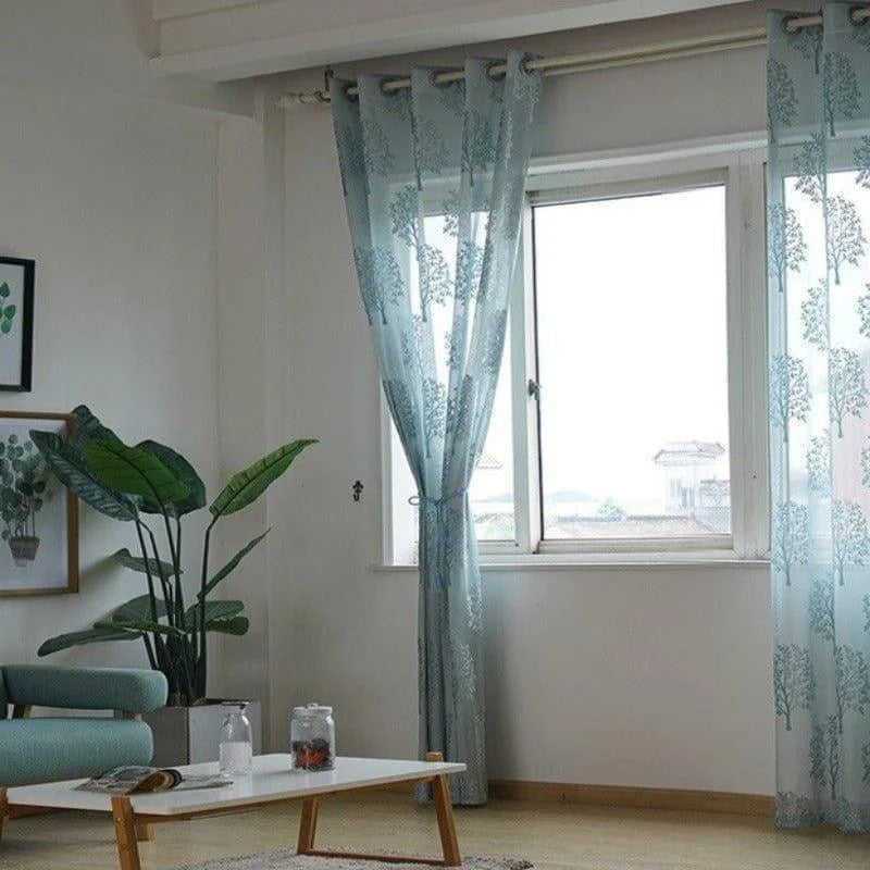 Rideaux transparents et élégants avec motifs, habillant une fenêtre dans un salon moderne, apportant une touche de déco lumineuse et naturelle. Idéal pour un intérieur contemporain et apaisant.
