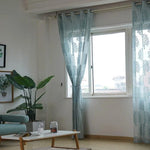 Rideaux transparents et élégants avec motifs, habillant une fenêtre dans un salon moderne, apportant une touche de déco lumineuse et naturelle. Idéal pour un intérieur contemporain et apaisant.