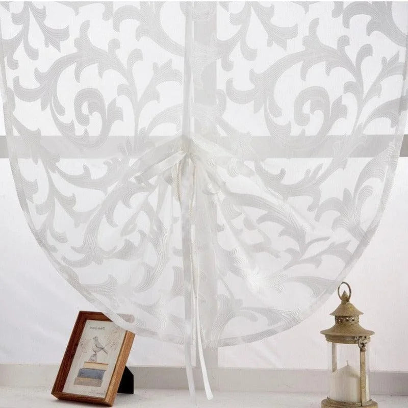 Rideau blanc à motifs élégants, idéal pour une décoration intérieure moderne et lumineuse. Parfait pour ajouter une touche de sophistication à votre salon ou chambre à coucher. Ce rideau est présenté avec une bougie décorative et un cadre photo sur un rebord, créant une ambiance chaleureuse et accueillante.