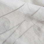 Voilage blanc avec motifs géométriques en spirale, idéal pour apporter une touche moderne et élégante à votre intérieur. Ce rideau lumineux et design s'intègre parfaitement dans tout type de décoration. Parfait pour réguler la lumière tout en préservant votre intimité.