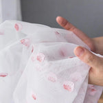 Voilage décoratif blanc avec motifs floraux roses, idéal pour la décoration intérieure contemporaine. Ce tissu design ajoute une touche élégante et légère à votre espace, parfait pour filtrer subtilement la lumière tout en embellissant vos fenêtres avec son motif délicat.