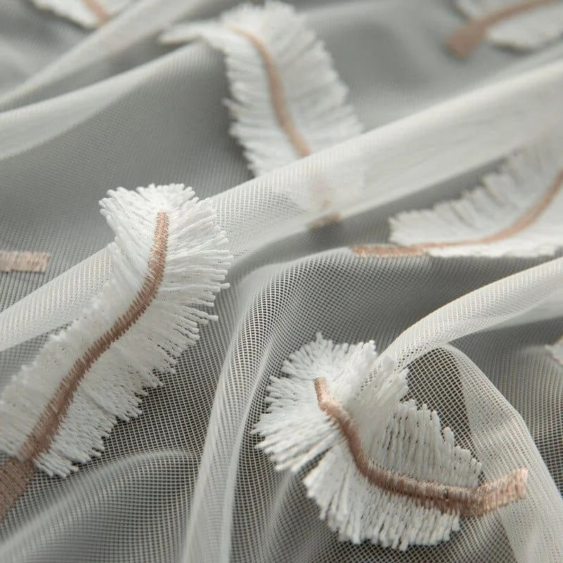 Tissu transparent avec des motifs brodés blancs et beiges, parfait pour la confection de vêtements élégants ou de décorations délicates. Design raffiné apportant une touche de sophistication à vos créations couture. Idéal pour robes, voilages ou accessoires de mode.