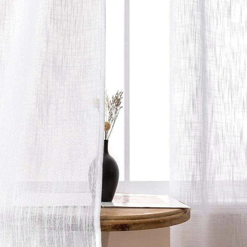Voilage blanc translucide élégant pour salon, laissant passer la lumière naturelle tout en préservant l'intimité. Idéal pour une décoration contemporaine et minimaliste. Placé devant une fenêtre, il offre une ambiance lumineuse et apaisante. Accessoire essentiel pour habiller vos fenêtres avec style.