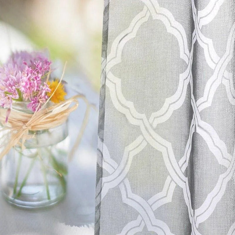 Rideau élégant à motifs géométriques gris et blancs, idéal pour ajouter une touche moderne à votre salon. Accompagnez votre décoration intérieure avec ce rideau chic, parfait pour filtrer la lumière tout en préservant votre intimité. Parfait pour une ambiance chaleureuse et accueillante, ce rideau se marie bien avec une décoration florale subtile.