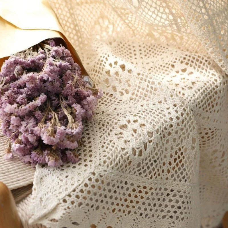 Nappe élégante au motif ajouré, mise en valeur par un bouquet de fleurs séchées violettes. Décoration idéale pour créer une ambiance romantique et chaleureuse dans votre intérieur. Parfaite pour les événements spéciaux ou un usage quotidien, cette nappe ajoutera une touche délicate et raffinée à votre table.