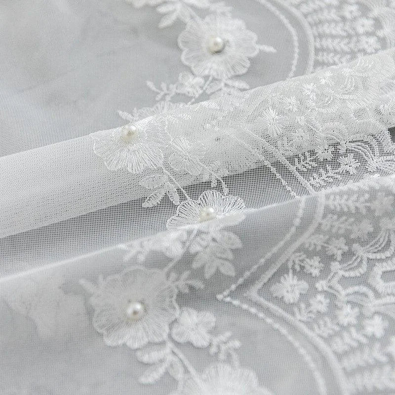 Superbe tissu orné de motifs floraux brodés et de perles délicates, idéal pour la confection de robes de mariée élégantes. Design raffiné et romantique pour des créations de haute couture. Convient également pour des accessoires ou des décorations de mariage sophistiquées.