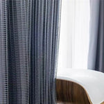 Rideau moderne à rayures verticales noires, parfait pour ajouter une touche élégante à votre salon ou chambre, avec une chaise de design contemporain en arrière-plan. Complément idéal pour la décoration intérieure.