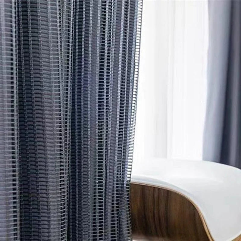 Rideau moderne à rayures verticales noires, parfait pour ajouter une touche élégante à votre salon ou chambre, avec une chaise de design contemporain en arrière-plan. Complément idéal pour la décoration intérieure.