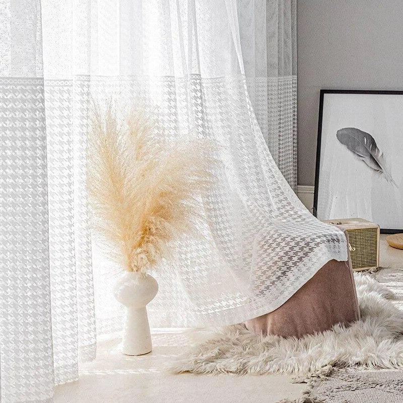 Voilage blanc élégant avec motif à chevrons, idéal pour créer une ambiance lumineuse et apaisante dans votre intérieur. Accessoirisé d'un vase décoratif et d'une œuvre artistique minimaliste, ce rideau apporte une touche de sophistication à votre salon ou chambre. Parfait pour un style contemporain et raffiné.